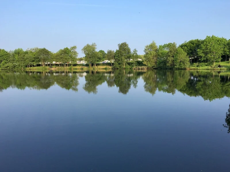 A scenic view of the tranquil, tree-lined Sunnyside One lake at the Wyreside Lakes complex in Lancashire.