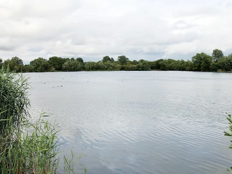 A stunning view of the crystal-clear waters of Christchurch lake at Linch Hill Fishery.