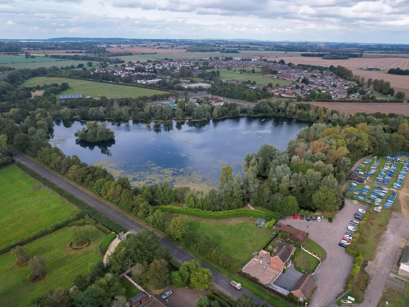 A scenic view of Orchid Lake at the Orchid Lakes fishery in Oxfordshire, a renowned day-ticket carp water.