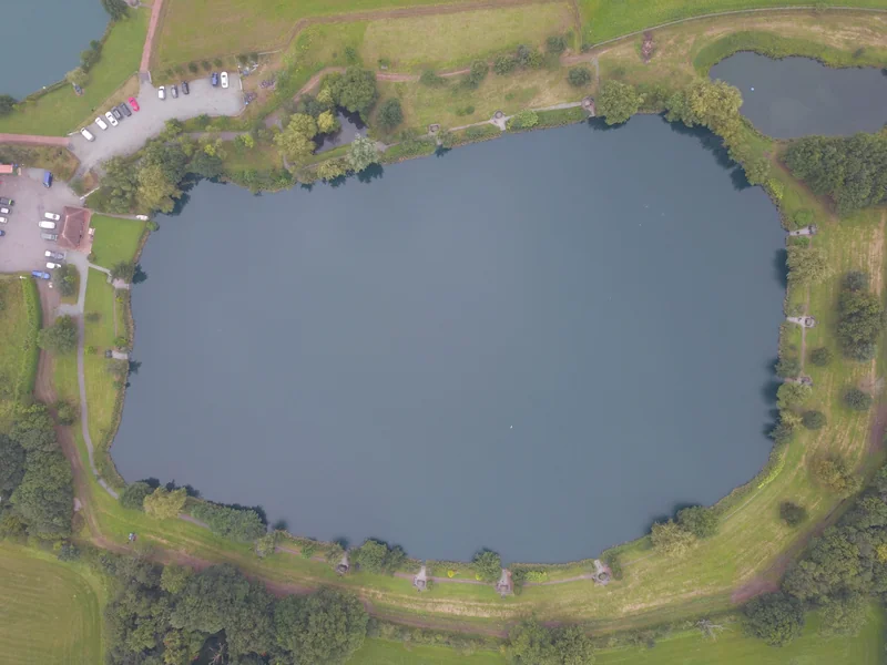 Monument 1 lake at RH Fisheries showing the 8.6 acre day ticket carp fishery with well-maintained swims and mature trees surrounding the water